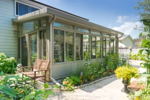 Solarium 3 saisons installé sur une terrasse avec des plantes.